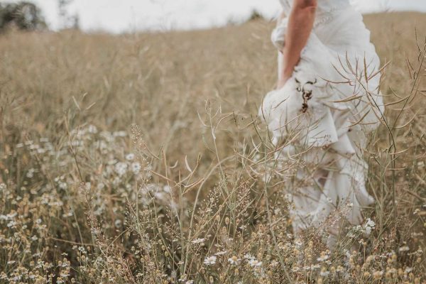 a bride standing in the middle of a field