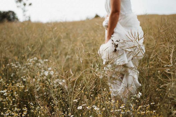 a bride standing in the middle of a field