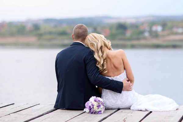 Wedding couple on lake pier