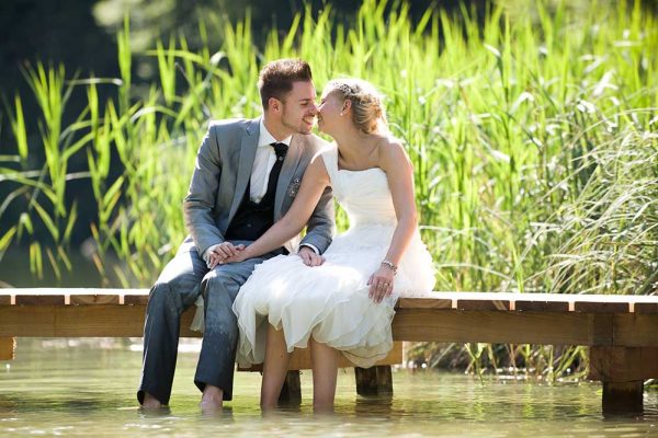 bride and groom in the nature sitting o a small lake